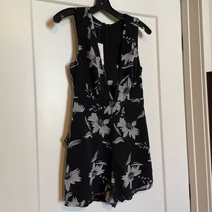Brand new. Never worn. Bebe romper. Tags still attached. Chiffon material.